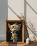 Framed artwork of an old cat holding a coffee cup next to a vase with dried plants